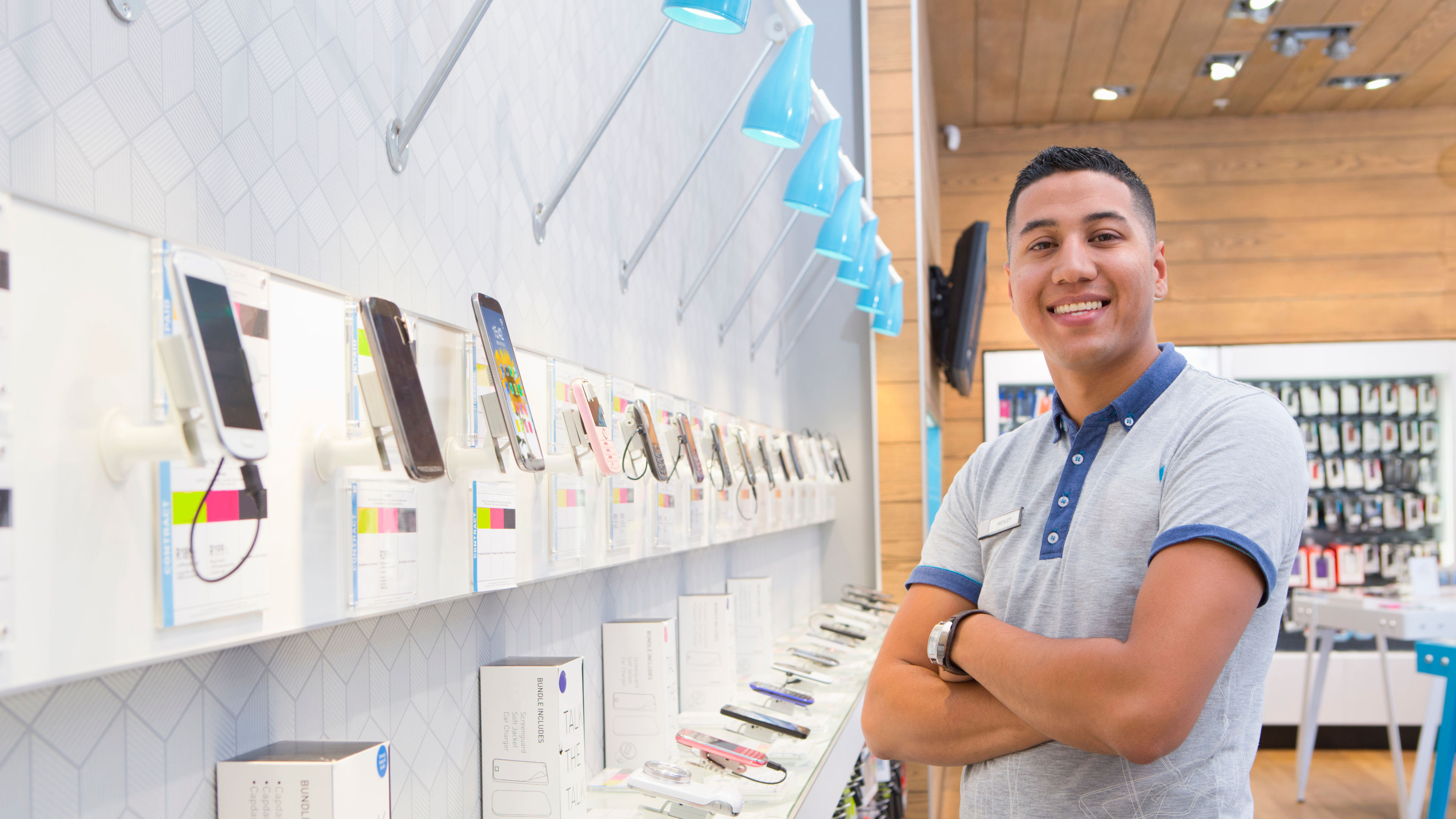 Store Assistant Standing Arms Crossed In A Phone Store